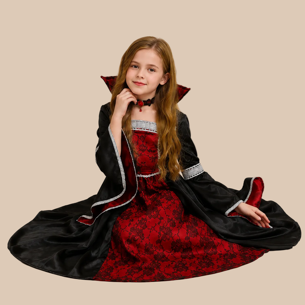 Girl’s long vampire dress with contrasting red front panel, shown in a seated pose