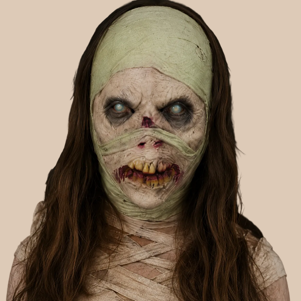 Mummy mask with bandaged face and long dark hair, worn on a model
